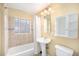 Cozy bathroom with a tub, pedestal sink, tiled walls, and a medicine cabinet for storage at 1363 Stuart St, Denver, CO 80204