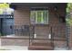 Inviting front porch with seating, a brick facade, and decorative iron railings at 1363 Stuart St, Denver, CO 80204