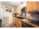 A functional kitchen with custom wood cabinets, stone tile backsplash, and a black granite countertop at 1363 Stuart St, Denver, CO 80204