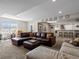 Finished basement area with L-shaped sofa, recessed lighting, bar with seating, and neutral carpet throughout at 15264 W La Salle Ave, Lakewood, CO 80228