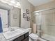 Bright bathroom features a double sink vanity, granite counters, and a shower with glass doors at 15264 W La Salle Ave, Lakewood, CO 80228