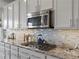 Modern kitchen with white cabinets, stainless appliances, granite countertops, and gas cooktop at 15264 W La Salle Ave, Lakewood, CO 80228