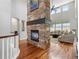 Inviting living room with hardwood floors, stone fireplace, and lots of natural light at 15264 W La Salle Ave, Lakewood, CO 80228
