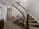 Beautiful staircase with curved banister, carpeted steps, and a nearby table with seating for a relaxing entry way at 15264 W La Salle Ave, Lakewood, CO 80228