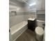 Well-lit bathroom featuring a tub with tiled walls, vanity and cabinet, toilet, and wood-look floors at 6139 S Adams Dr, Centennial, CO 80121