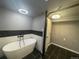 Chic bathroom featuring a freestanding tub, modern fixtures, and sleek black tile flooring with a chandelier at 6139 S Adams Dr, Centennial, CO 80121