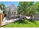 Backyard featuring a deck, a small stone patio, a lush lawn, and mature trees for shade at 321 S Emerson St, Denver, CO 80209