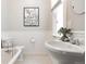 Charming bathroom features vintage-style fixtures, a pedestal sink, and natural light at 321 S Emerson St, Denver, CO 80209