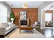 Bright living room boasts a brick fireplace, plush seating, and a stylish modern aesthetic at 321 S Emerson St, Denver, CO 80209