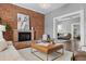 Comfortable living room featuring exposed brick, a fireplace, and stylish decor at 321 S Emerson St, Denver, CO 80209