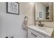 Chic half-bath featuring elegant mirror, stylish vanity, and decorative wall art at 23413 E Dorado Pl # A, Aurora, CO 80016