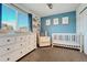 Well-lit Bedroom features a crib, dresser, cozy chair and blue accent wall at 23413 E Dorado Pl # A, Aurora, CO 80016