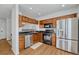 Well-equipped kitchen with stainless steel appliances, wooden cabinets, and modern fixtures at 23413 E Dorado Pl # A, Aurora, CO 80016