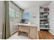 Bright office space features hardwood flooring, built-in shelving, and a large window for natural light at 23413 E Dorado Pl # A, Aurora, CO 80016