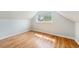 Attic bedroom featuring hardwood floors, large window and freshly painted white walls at 3921 S Acoma St, Englewood, CO 80110