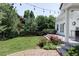Beautifully landscaped backyard with a patio, grassy area, mature trees, and outdoor lighting, creating a serene and inviting space at 8739 E 23Rd Ave, Denver, CO 80238