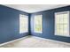 A blue-walled bedroom is brightened by three large windows, enhancing the room's appeal at 8739 E 23Rd Ave, Denver, CO 80238