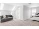 A bright bedroom with a gray sofa features neutral tones and natural light from a skylight at 8739 E 23Rd Ave, Denver, CO 80238