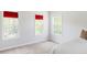Minimalist bedroom with bright, neutral walls, carpet, and several large windows with red blinds at 8739 E 23Rd Ave, Denver, CO 80238