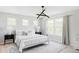 Bright bedroom with a large bed, contemporary lighting, neutral decor, and multiple windows at 8739 E 23Rd Ave, Denver, CO 80238