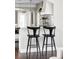 Kitchen island with bar seating, pendant lighting, and modern fixtures at 8739 E 23Rd Ave, Denver, CO 80238