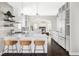 Open kitchen with island seating, stainless appliances and view into living room at 8739 E 23Rd Ave, Denver, CO 80238