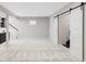 A spacious room features light colored walls and carpet, as well as, sliding barn doors at 8739 E 23Rd Ave, Denver, CO 80238