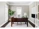 Well-lit home office with dark wood desk, white trim, large windows, and modern décor at 8739 E 23Rd Ave, Denver, CO 80238