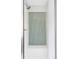 Bright, walk-in shower features white tiles, vertical green accent tile, and shower bench seating at 8739 E 23Rd Ave, Denver, CO 80238