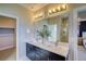 Bathroom with double vanity, large mirror and a view of the shower and bedroom at 8795 Hugo Dr, Littleton, CO 80125
