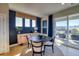 A modern dining room with dark accent wall and view of mountains from the outdoor patio at 8795 Hugo Dr, Littleton, CO 80125
