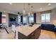 Modern open floor plan featuring a kitchen with island, living area with fireplace, and dining area at 8795 Hugo Dr, Littleton, CO 80125