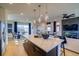 Open-concept floor plan with modern kitchen island, dining area, and living area with a fireplace at 8795 Hugo Dr, Littleton, CO 80125