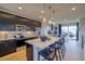 Kitchen featuring dark cabinetry, stainless appliances, an island with seating, and views to patio at 8795 Hugo Dr, Littleton, CO 80125