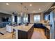A modern open kitchen and living area concept with an island, pendant lighting, and stainless appliances at 8795 Hugo Dr, Littleton, CO 80125