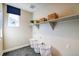 Well-organized laundry room with shelving, baskets, a window, and modern flooring at 8795 Hugo Dr, Littleton, CO 80125