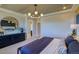 Bright main bedroom featuring a modern chandelier, round mirror and a navy color scheme at 8795 Hugo Dr, Littleton, CO 80125