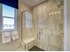 New bathroom shower with a glass door, bench, and beige tile surround in a new home at 8795 Hugo Dr, Littleton, CO 80125