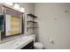 Bathroom vanity has drawers, a large mirror, decorative shelving, and a shower with a striped curtain at 17151 E Stanford Ave # B, Aurora, CO 80015