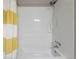 The bathroom features a tub with white tile, a shower head, and a yellow and white curtain at 17151 E Stanford Ave # B, Aurora, CO 80015