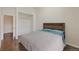 Bedroom features wood floors, a wood frame bed, and a closet with hanging rods at 17151 E Stanford Ave # B, Aurora, CO 80015