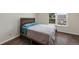 Cozy bedroom showcases hardwood floors, a wood-frame bed, and a window with neighborhood views at 17151 E Stanford Ave # B, Aurora, CO 80015