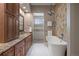 Luxurious bathroom featuring granite counters, dual sinks, a standalone tub, and decorative tile work at 4336 Chateau Ridge Rd, Castle Rock, CO 80108