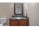 Well-lit powder room with a decorative mirror, granite countertop, and stylish fixtures at 4336 Chateau Ridge Rd, Castle Rock, CO 80108
