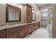 Spacious bathroom with double sinks, granite countertops, wooden cabinetry, and a modern soaking tub at 4336 Chateau Ridge Rd, Castle Rock, CO 80108