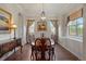 Formal dining room featuring hardwood floors, elegant chandelier, and large windows with decorative curtains at 4336 Chateau Ridge Rd, Castle Rock, CO 80108