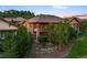 Attractive exterior view showcasing the multi-level deck surrounded by lush landscaping at 4336 Chateau Ridge Rd, Castle Rock, CO 80108