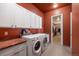 Functional laundry room equipped with a washer, dryer, ample storage cabinets, and granite countertop at 4336 Chateau Ridge Rd, Castle Rock, CO 80108