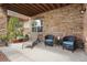 Cozy covered patio with stone wall, comfortable seating and lots of space at 4336 Chateau Ridge Rd, Castle Rock, CO 80108