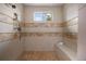 Modern shower with tiled walls, a built-in bench, and a window providing natural light at 4336 Chateau Ridge Rd, Castle Rock, CO 80108